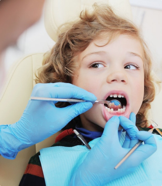Осмотр пациента детским стоматологом